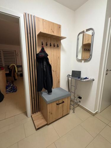 a room with a wooden door with a bench and a mirror at FeWo Köhler Kölpinsee in Loddin