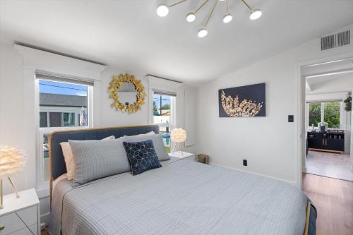 Un dormitorio blanco con una cama y un espejo. en Casa Lumina, en Phoenix