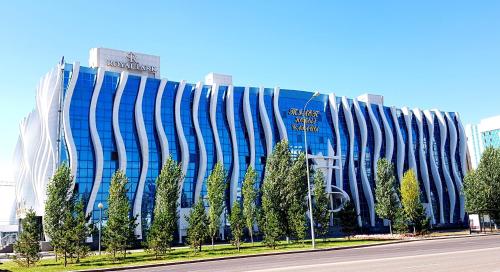 a large blue building with trees in front of it at REIKARTZ PARK ASTANA ex-Royal Park Hotel & SPA in Astana
