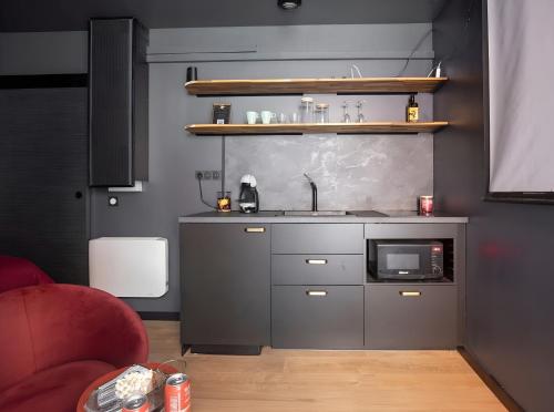 une cuisine avec un évier et un micro-ondes dans l'établissement La cinemaRoom d'Auterive - Son Immersif Dolby et Atmos - Netflix, à Auterive