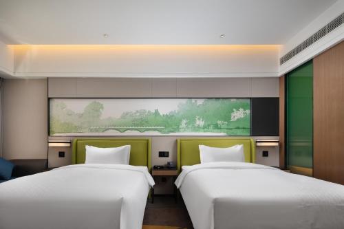 twee bedden in een kamer met een groot raam bij Hilton Garden Inn Chengde Mountain Resort in Niuquanzigou