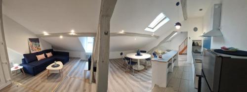 Una sala de estar con un sofá azul y una mesa. en Le grand logis de Meung Sur Loire, en Meung-sur-Loire