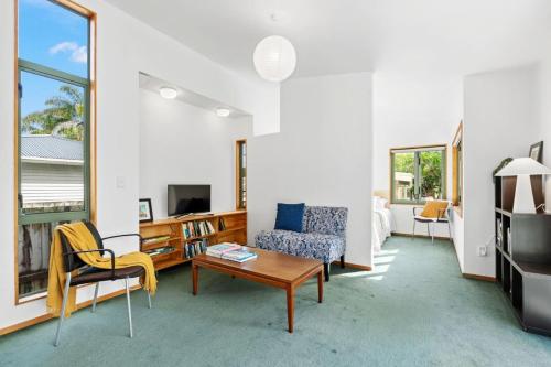 a living room with a couch and a table at Water's Edge Stay in Central Whangarei in Whangarei