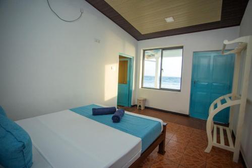 a bedroom with a bed with a chair and a window at Villa Amor by the Beach in Ambalangoda