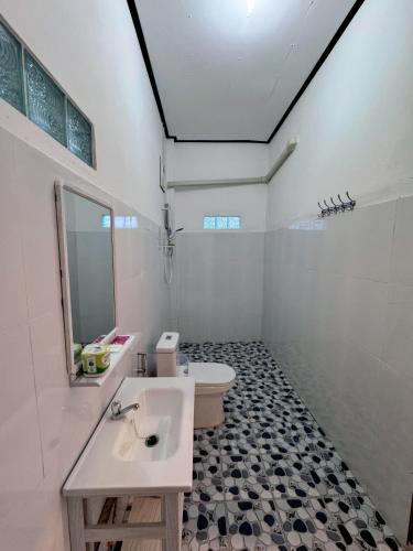 a bathroom with a sink and a toilet and a mirror at phoulisack2 guesthouse in Nongkhiaw