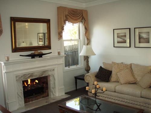 a living room with a couch and a fireplace at Jamieson Cottage in Warrnambool