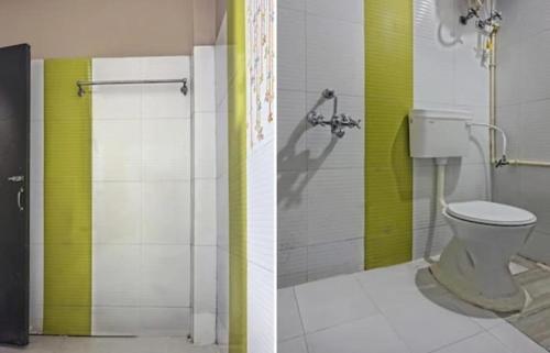 a bathroom with a toilet and a green and white wall at Hotel Grand Stay in Bhopal