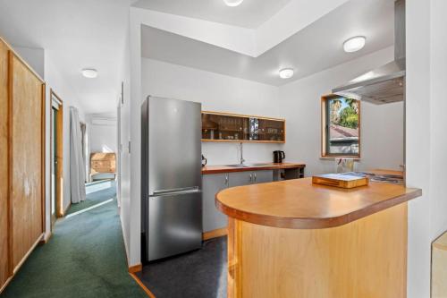 a kitchen with a stainless steel refrigerator and a wooden counter at Water's Edge Stay in Central Whangarei in Whangarei