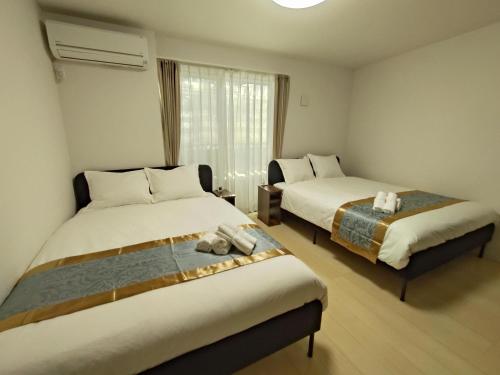 a hotel room with two beds and a window at 南公園スカイビュー in Tokyo