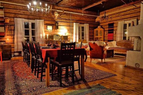 une salle à manger avec une table et des chaises rouges dans l'établissement Aurora Cottage Otsola - A Cozy Lakefront Wilderness Hideaway, 55 km from Rovaniemi, à Rovaniemi