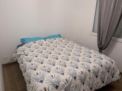 Schlafzimmer mit einem Bett mit einer weißen und blauen Bettdecke in der Unterkunft La Casa Blanca 