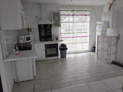 eine Küche mit weißen Schränken und einem Fliesenboden in der Unterkunft La Casa Blanca 