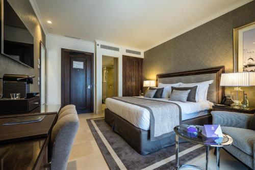 a hotel room with a bed and a living room at Herbert Samuel Jerusalem in Jerusalem