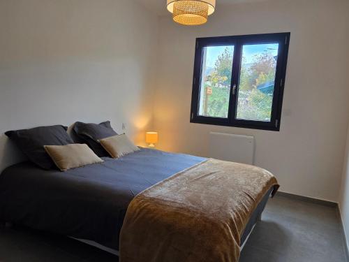 a bedroom with a large bed with a window at Le chalet du Petit Ours Brun in Formiguères