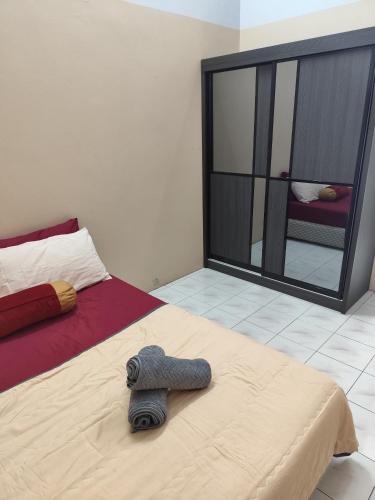 a bedroom with a bed with a towel on it at AHA Homestay Temerloh with 3 bedrooms, 2 toilet in Temerloh
