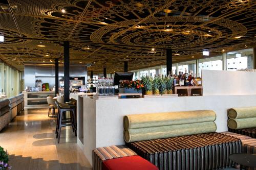 a restaurant with a counter and a bar with stools at Herbert Samuel Jerusalem in Jerusalem