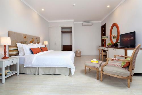 a bedroom with a large white bed and a chair at Villa Aria Boutique Muine in Mui Ne