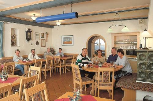 a group of people sitting at tables in a restaurant at Hotel-Gasthof Zur Linde in Neukirchen beim Heiligen Blut