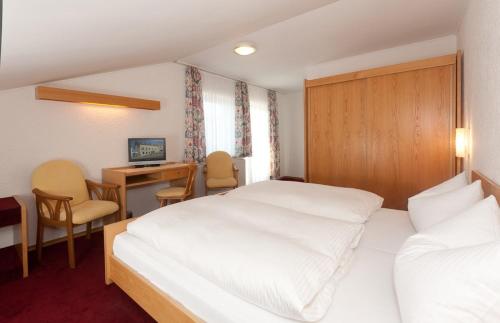 a hotel room with two beds and a desk at Hotel-Gasthof Zur Linde in Neukirchen beim Heiligen Blut