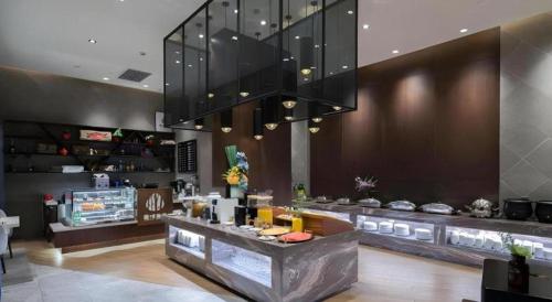 a restaurant with a counter and a large chandelier at Ease Hotel Xi'an High-tech Zone 4th Zhangba Road Metro Station in Xi'an