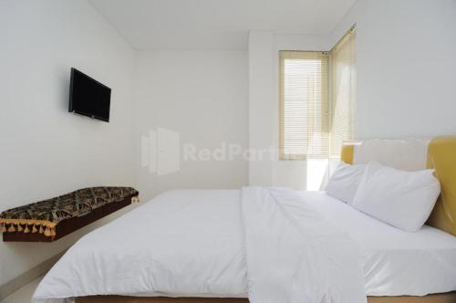 a white bedroom with a bed and a tv on the wall at Green Residence 25 Syariah Karawaci RedPartner in Binong