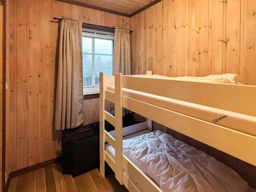 Un dormitorio con dos literas y una ventana. en 9 person holiday home in BJELLAND, en Bjelland