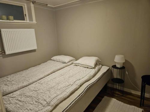 a bed with two pillows on it in a room at Liten lägenhet i Smedby, Norrköping in Norrköping