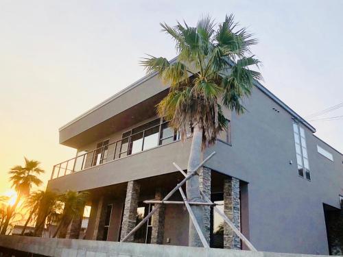 a building with a palm tree in front of it at The House of Ocean in Nachikatsuura