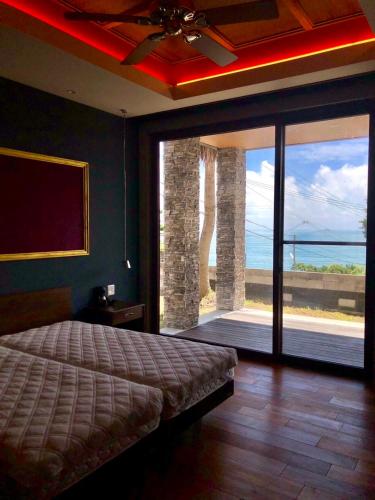 a bedroom with a bed and a large sliding glass door at The House of Ocean in Nachikatsuura