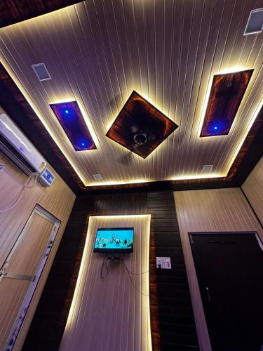 a room with a tv and a ceiling with lights at Rita Shree Homestay At Ayodhya Highway in Sultānpur