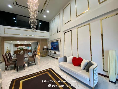 a living room with a couch and a dining room at Peema Villa ภีมะ วิลล่า in U Thong