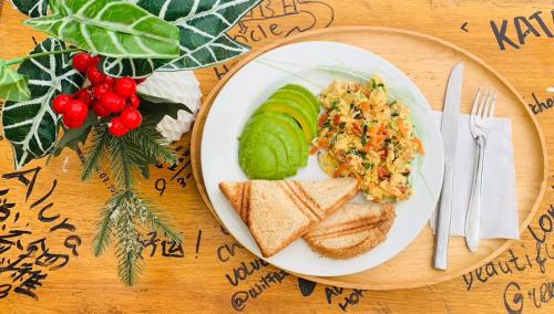 un plato de comida con pan y verduras y un sándwich en Alura Hostel, en Kata Beach