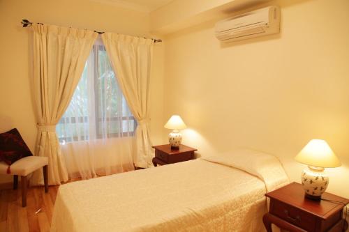 - une chambre avec un lit blanc et une fenêtre dans l'établissement Mayfair Hanoi, à Hanoï