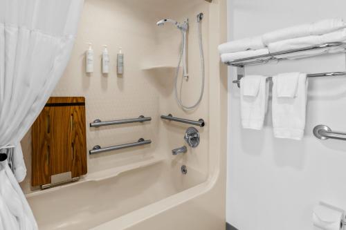 a bathroom with a shower and a tub with towels at Spark by Hilton Lynchburg in Lynchburg
