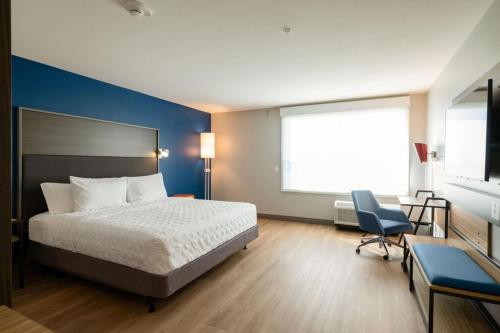 a bedroom with a bed and a desk and a chair at Tru By Hilton Grimes Des Moines in Grimes