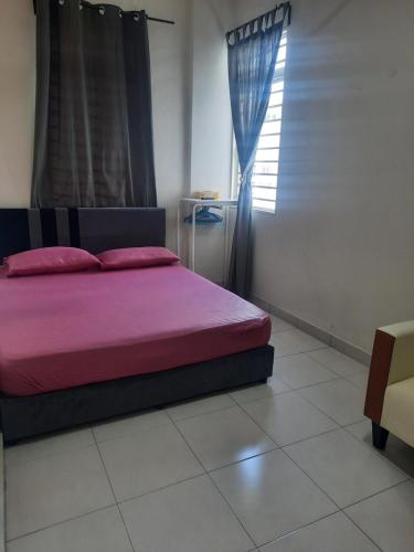 a bedroom with a bed with pink sheets and a window at Ratu Musleem Homestay in Kuala Selangor