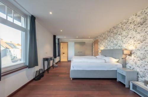 een slaapkamer met een groot wit bed en een raam bij Gastenkamer BLOOM in Brugge