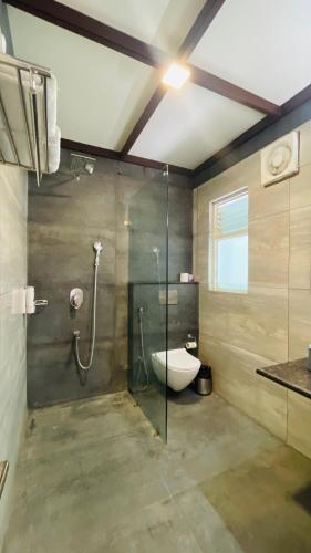 a bathroom with a glass shower and a toilet at Big Mama Corbett in Belparāo