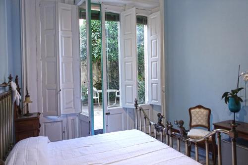 Schlafzimmer mit einem Bett und einer Glasschiebetür in der Unterkunft Inn Liberty in Giarre