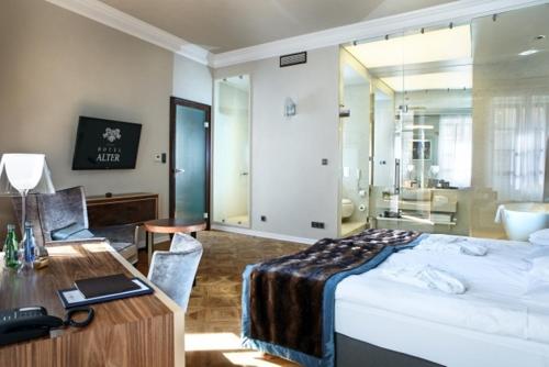 a hotel room with a bed and a desk and a bedroom at Hotel Alter in Lublin