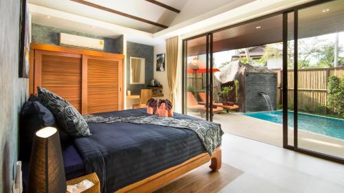 a bedroom with a bed and a swimming pool at Khwan Beach Resort - Luxury Glamping and Pool Villas Samui - Adults Only - SHA Extra Plus in Mae Nam