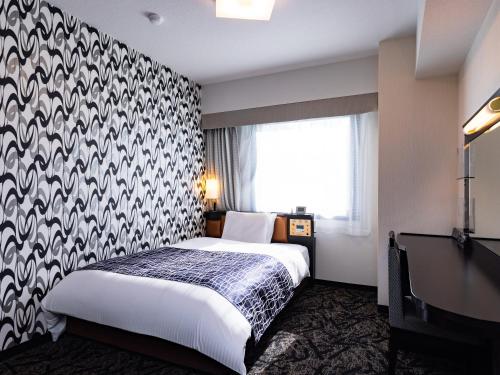 a hotel room with a bed and a window at APA Hotel Kitakami Ekinishi in Kitakami
