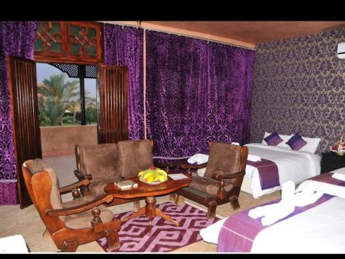 a bedroom with a bed and a table and chairs at Riad Mhidou Marrakech in Marrakesh