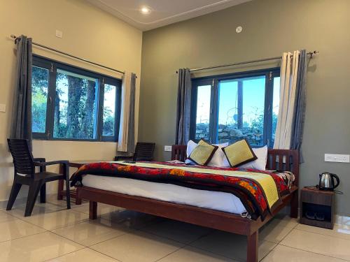a bedroom with a bed and two windows at 11 Gaon Homestay Lansdowne in Lansdowne