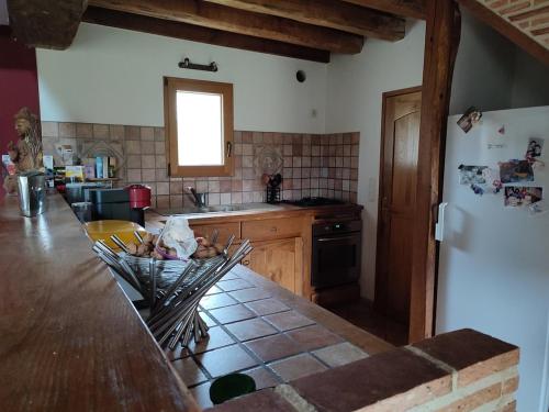 Maison Le Mans في Teloché: مطبخ مزود بمنضدة وثلاجة