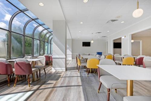 a dining room with tables and chairs and windows at The Lux Hotel & Conference Center, an Ascend Collection Hotel in Waterloo