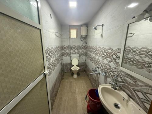 a bathroom with a toilet and a sink at Hotel Green Forest Mahableshwar in Mahabaleshwar
