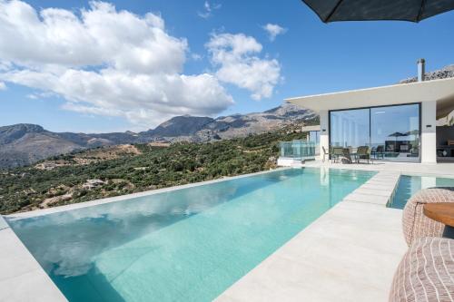 a villa with a swimming pool with mountains in the background at Dione Villa in Sellía
