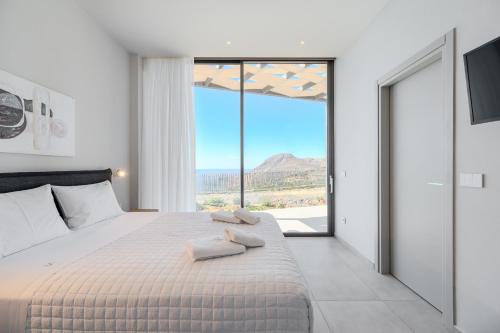 Un dormitorio con una cama con dos toallas encima. en Dione Villa, en Sellía