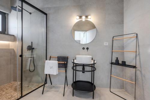 Un baño con ducha, lavabo y espejo. en Dione Villa, en Sellía